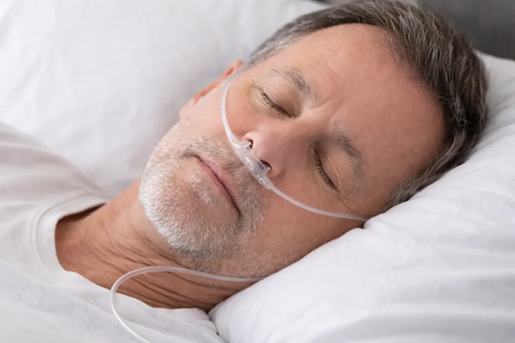 A man with respiratory problems resting with a nasal mask and oxygen concentrator